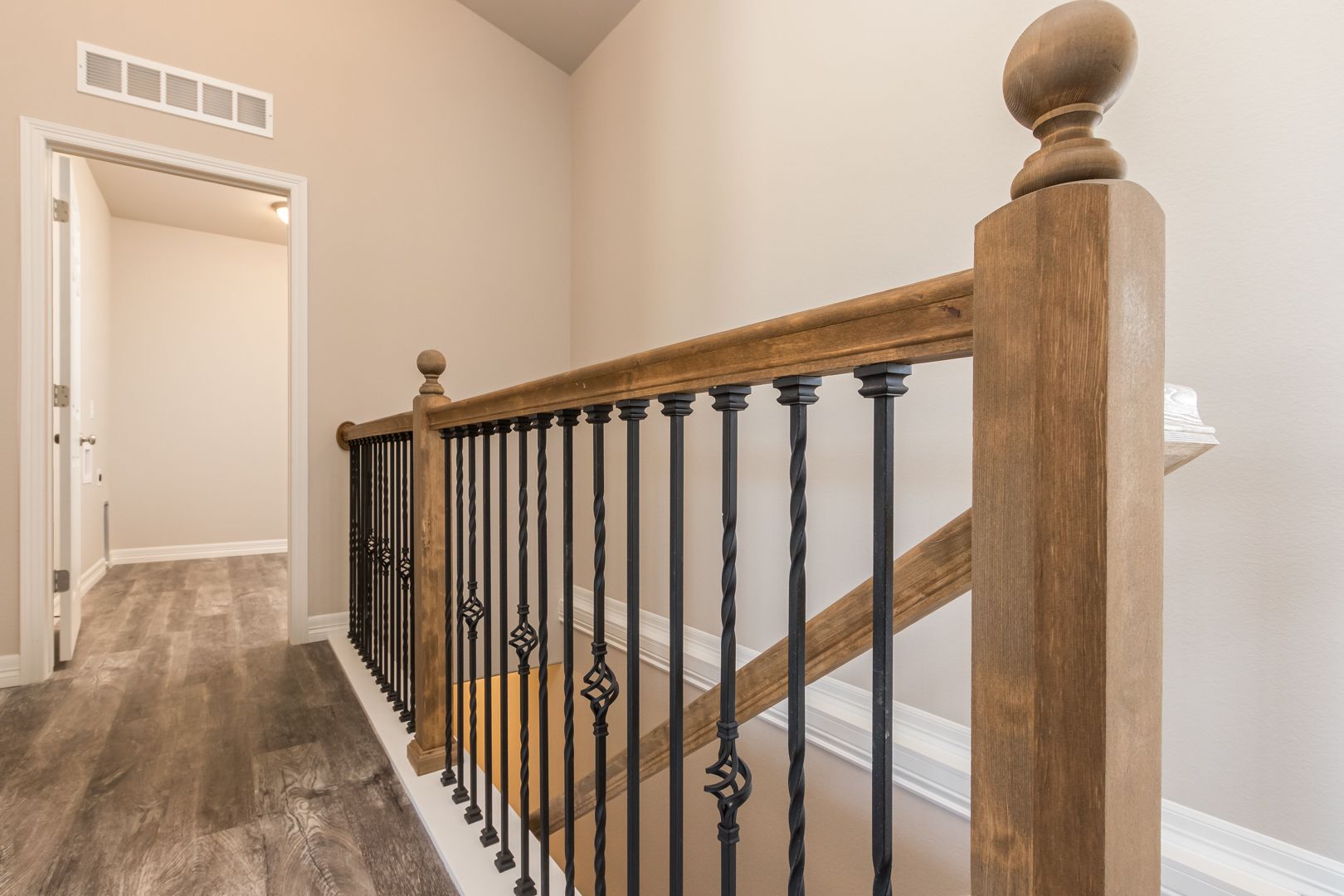 A staircase with a wooden railing and a metal railing in a house.