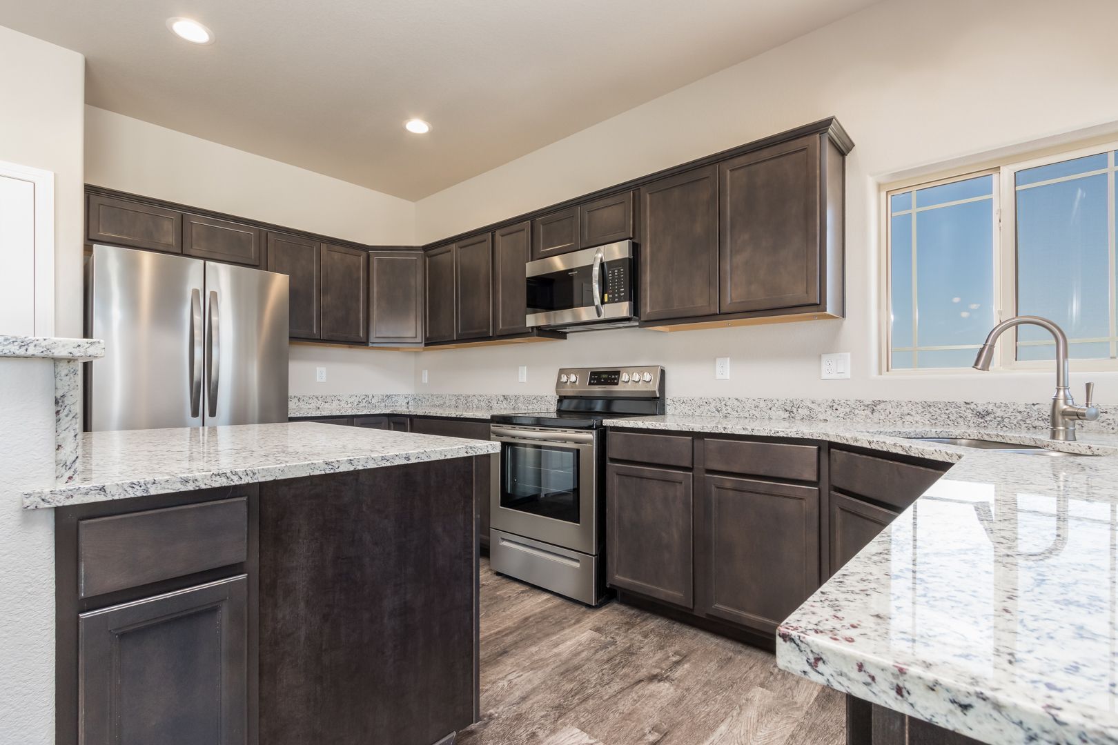 A kitchen with stainless steel appliances and granite counter tops.