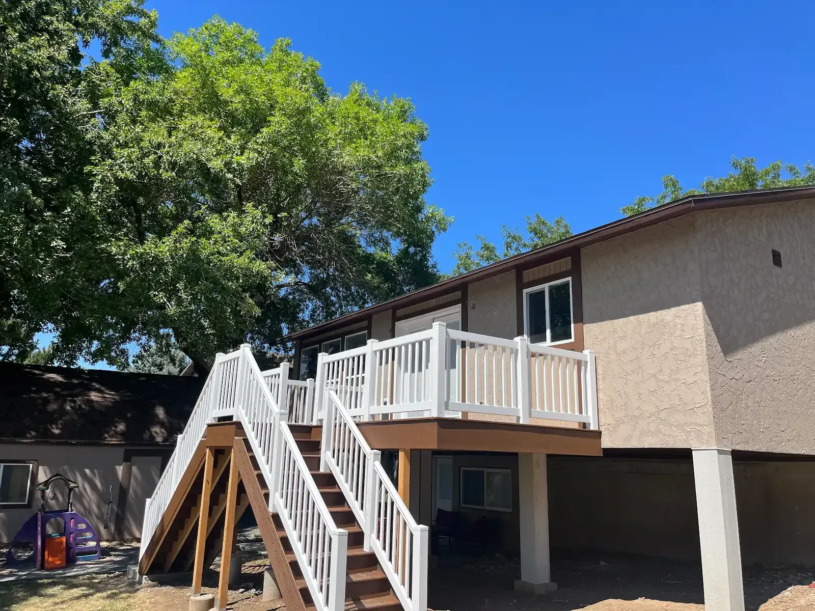 A house with a large deck and stairs leading up to it.