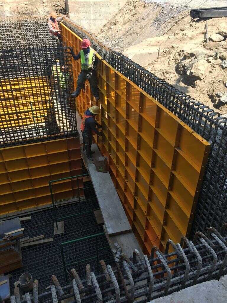 Un grupo de trabajadores de la construcción está trabajando en una pared en un sitio de construcción.