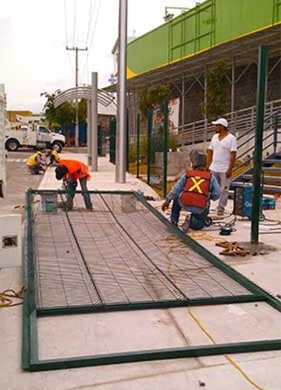 Un grupo de trabajadores de la construcción está trabajando en una valla frente a un edificio.