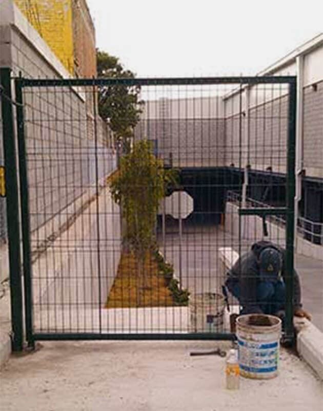 Un hombre está trabajando en una puerta frente a un edificio.