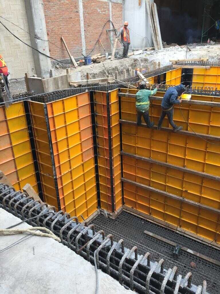 Un grupo de trabajadores de la construcción están trabajando en un edificio en construcción.