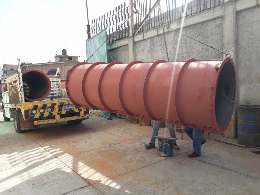 Se está cargando un gran tubo rojo en un camión.