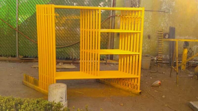 Una valla de metal amarillo está sentada en el suelo de una fábrica.