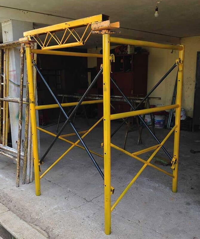 Un andamio amarillo está sentado frente a un edificio.