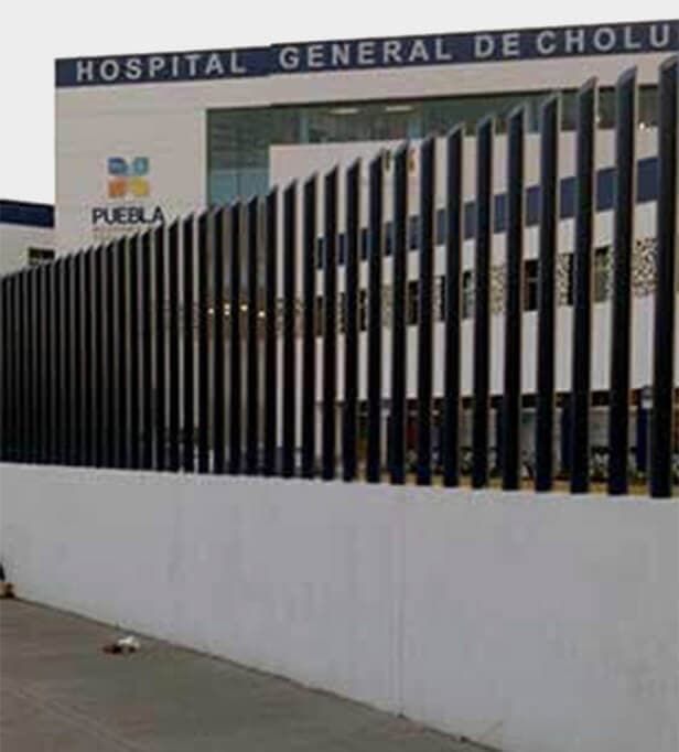 Un hospital con una valla alrededor y un cartel que dice hospital general de cholu