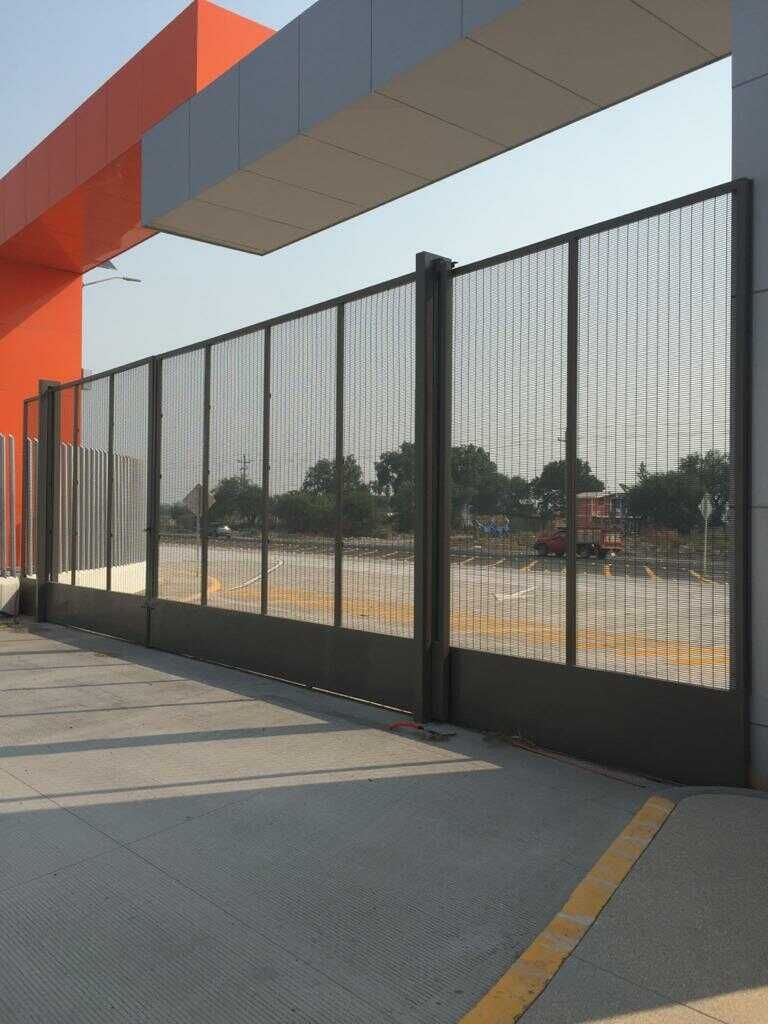 Una valla rodea un estacionamiento y un edificio