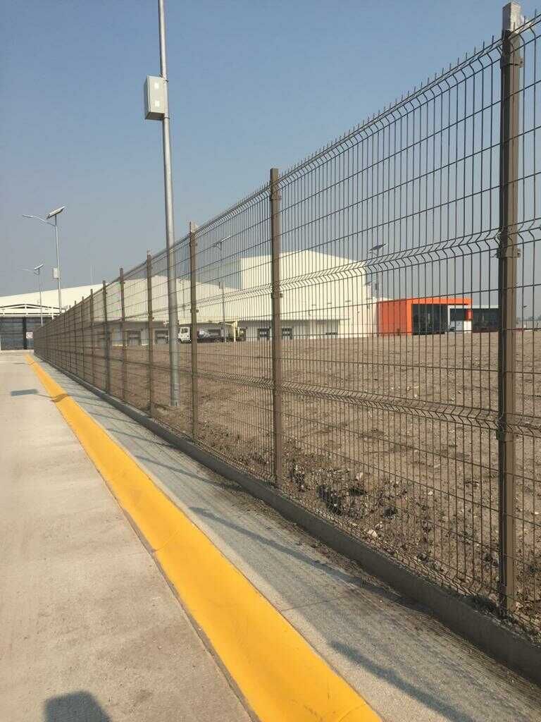 Una valla al costado de una carretera con una línea amarilla.