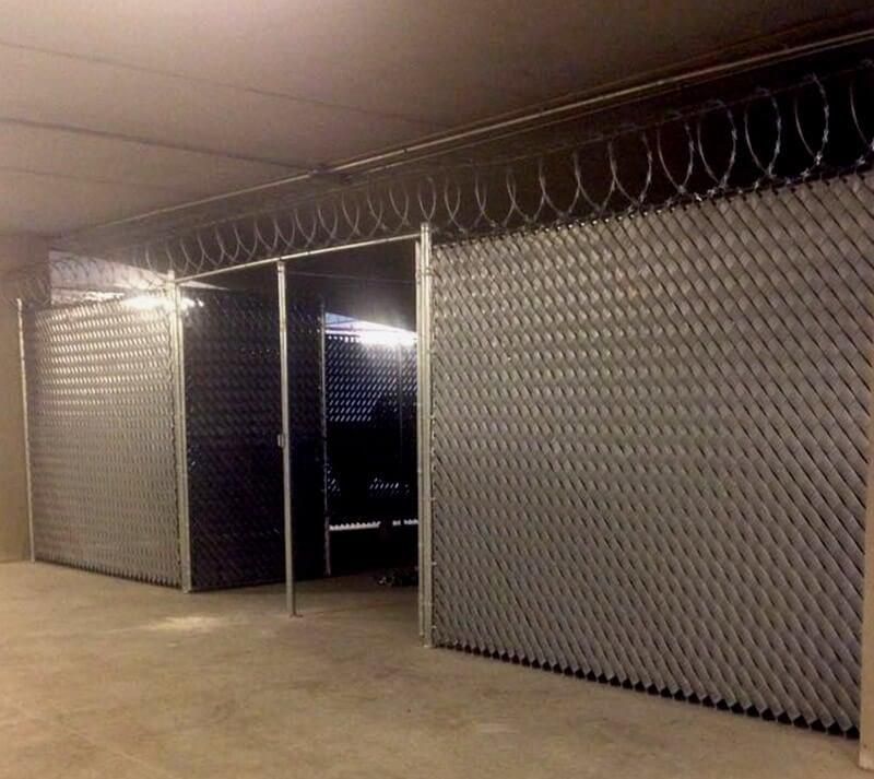 Una habitación con vallas metálicas y alambre de púas colgando del techo