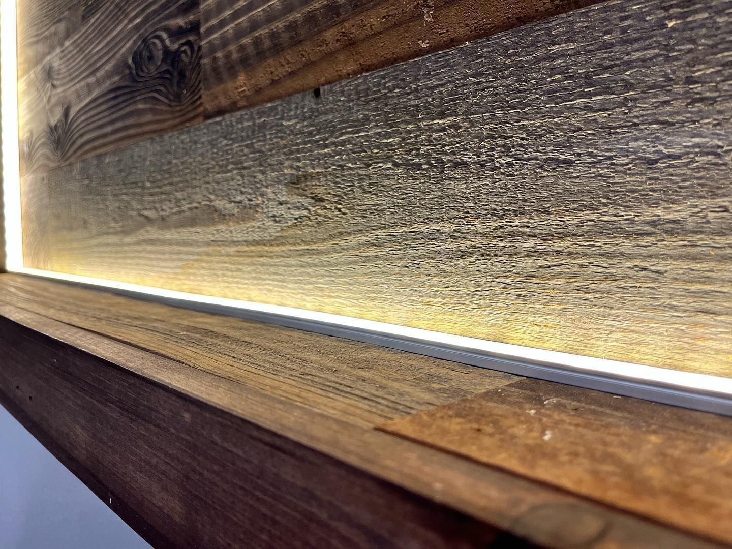Wooden wall with recessed linear lighting.