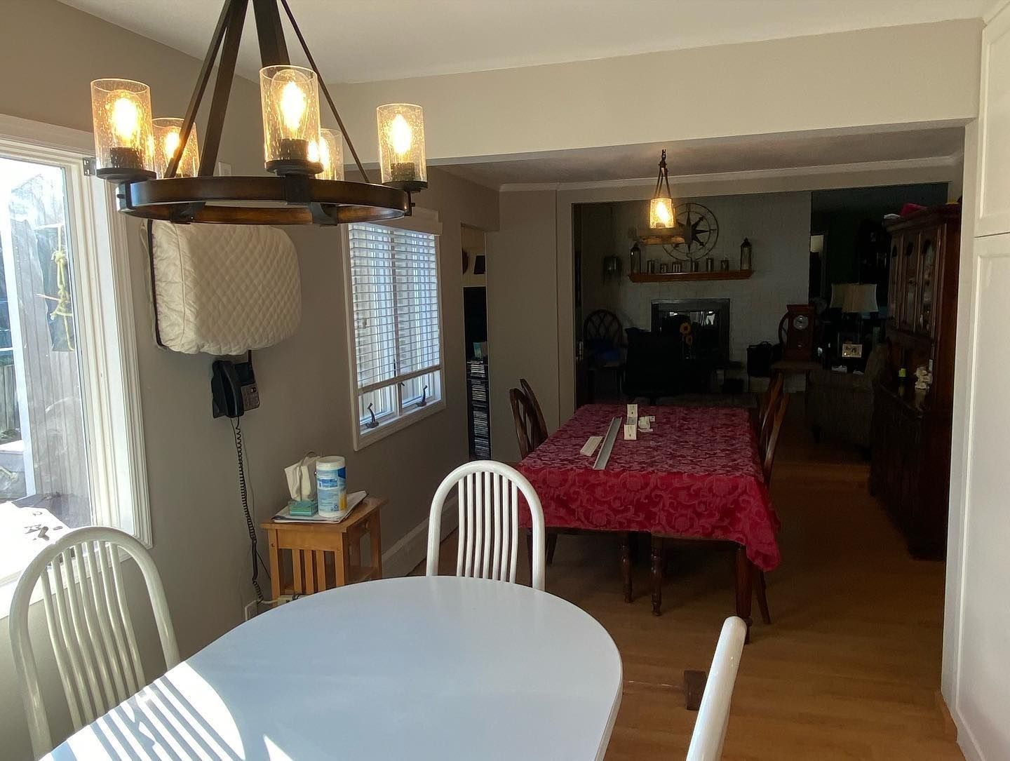 Dining room with a chandelier, round table, and a long table in the background.