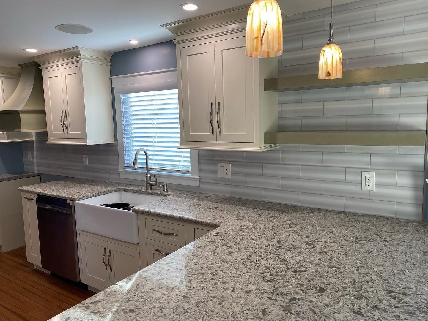 Modern kitchen with white cabinets, quartz countertops, and a farmhouse sink.