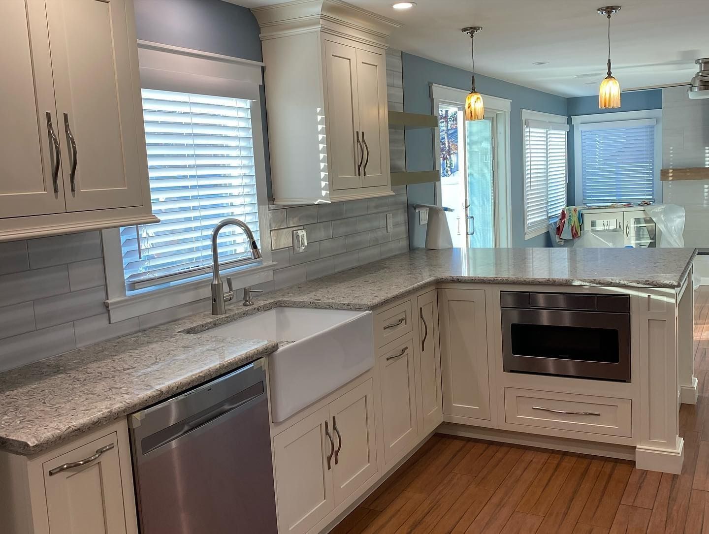 Cream kitchen with granite counters, stainless steel appliances, and wood floors.
