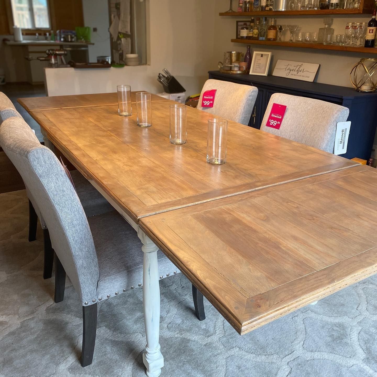 Wooden dining table with chairs. Table is set with glasses.