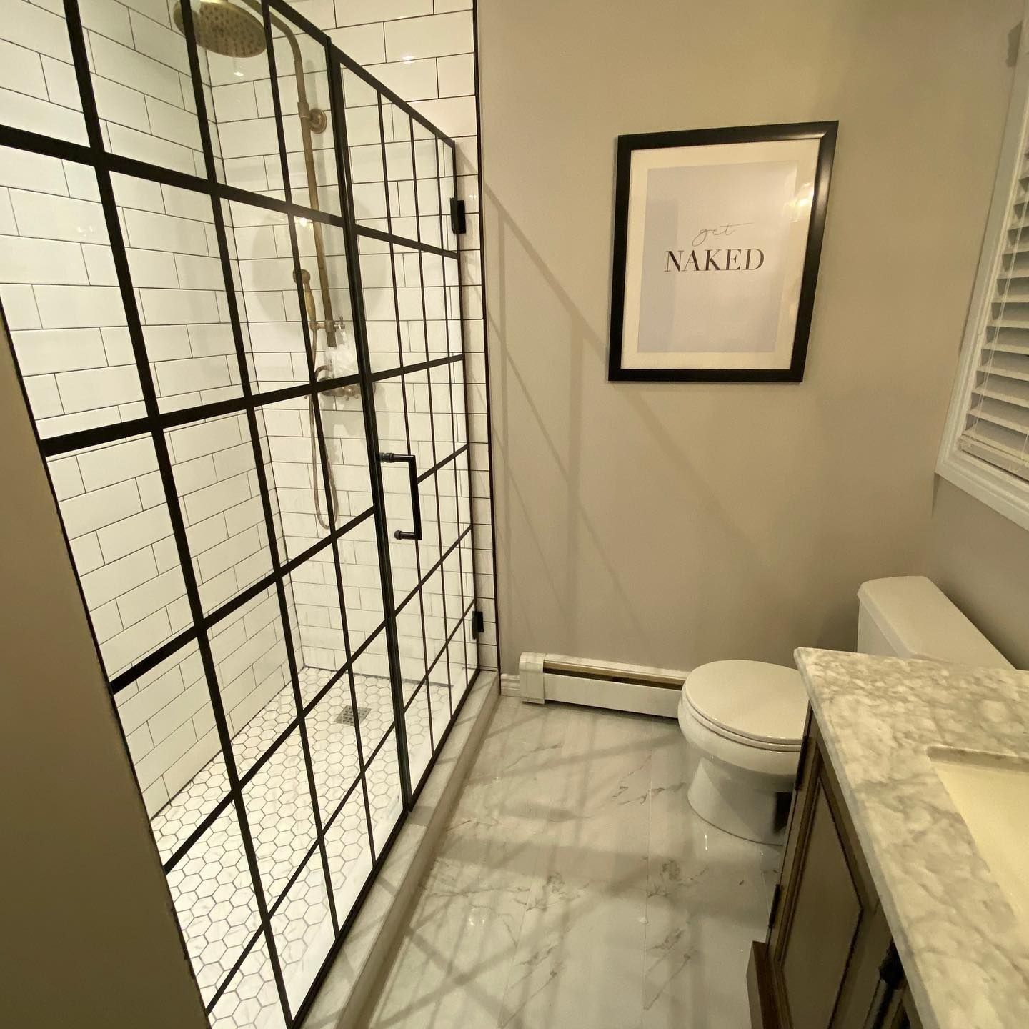 Bathroom with black framed shower, white subway tile, and a 
