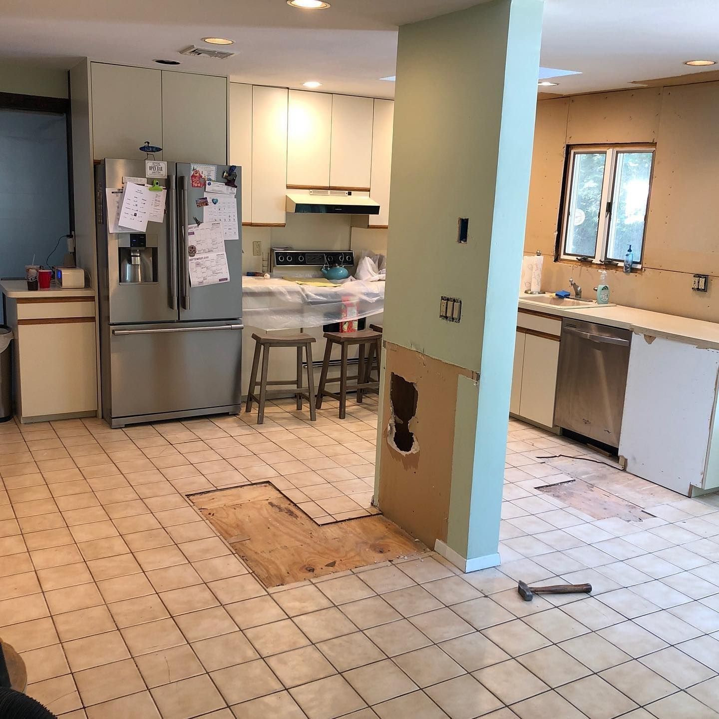 Kitchen undergoing renovation with exposed flooring and cabinets.
