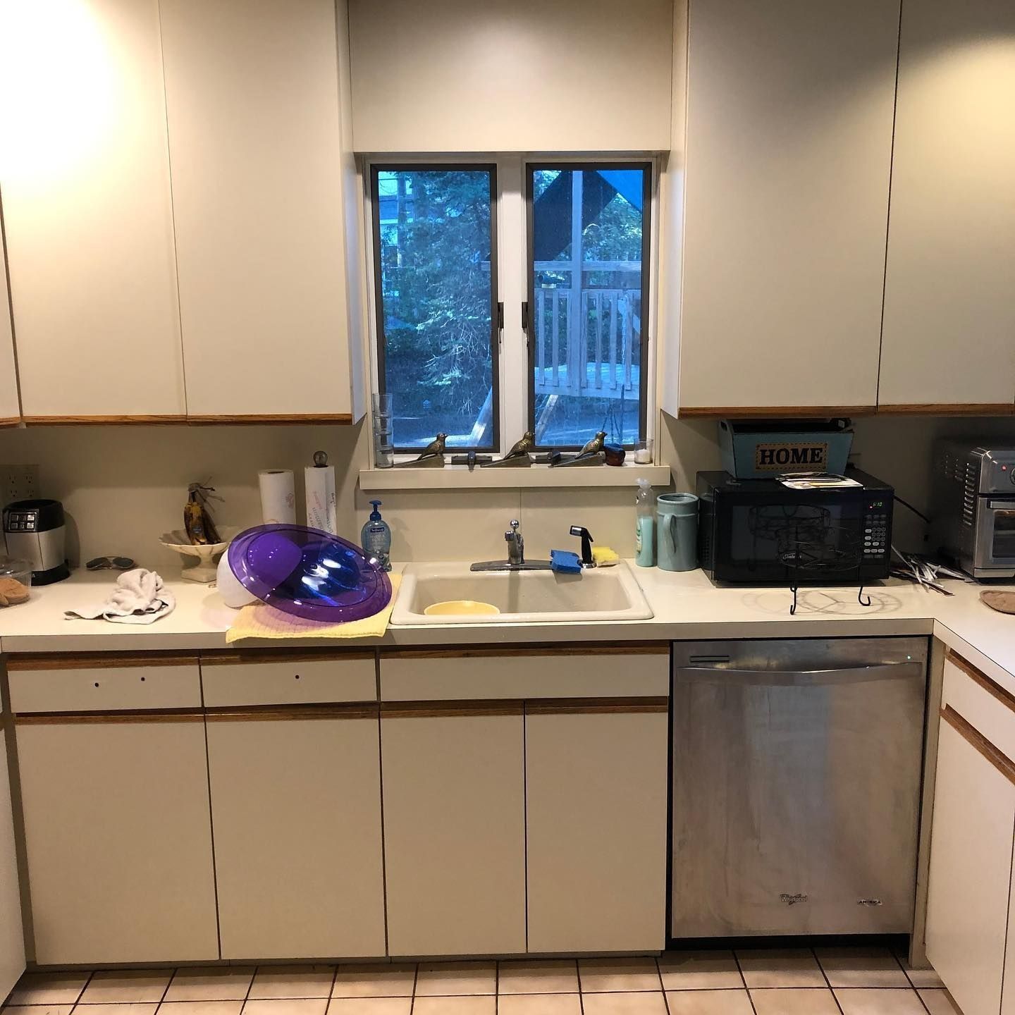 Kitchen with white cabinets, stainless steel appliances, and a window.