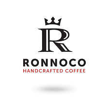 A person is holding a pile of coffee beans in their hands.