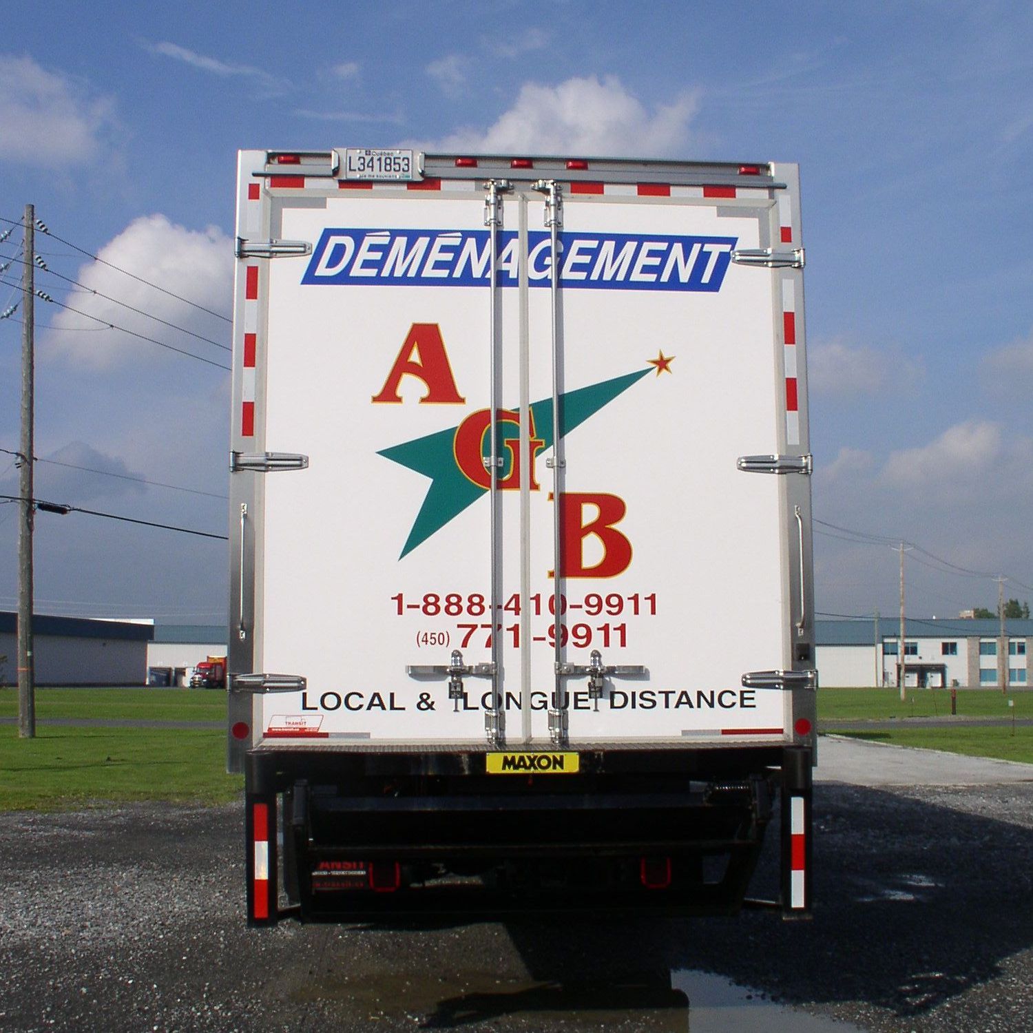 À l'arrière d'un camion de déménagement, on peut lire le nom de la société « DÉMÉNAGEMENT ». 