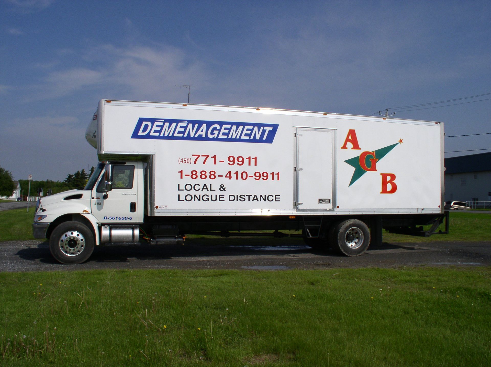 Un couple de personnes âgées transportant des cartons près d'un escalier, en mouvement.