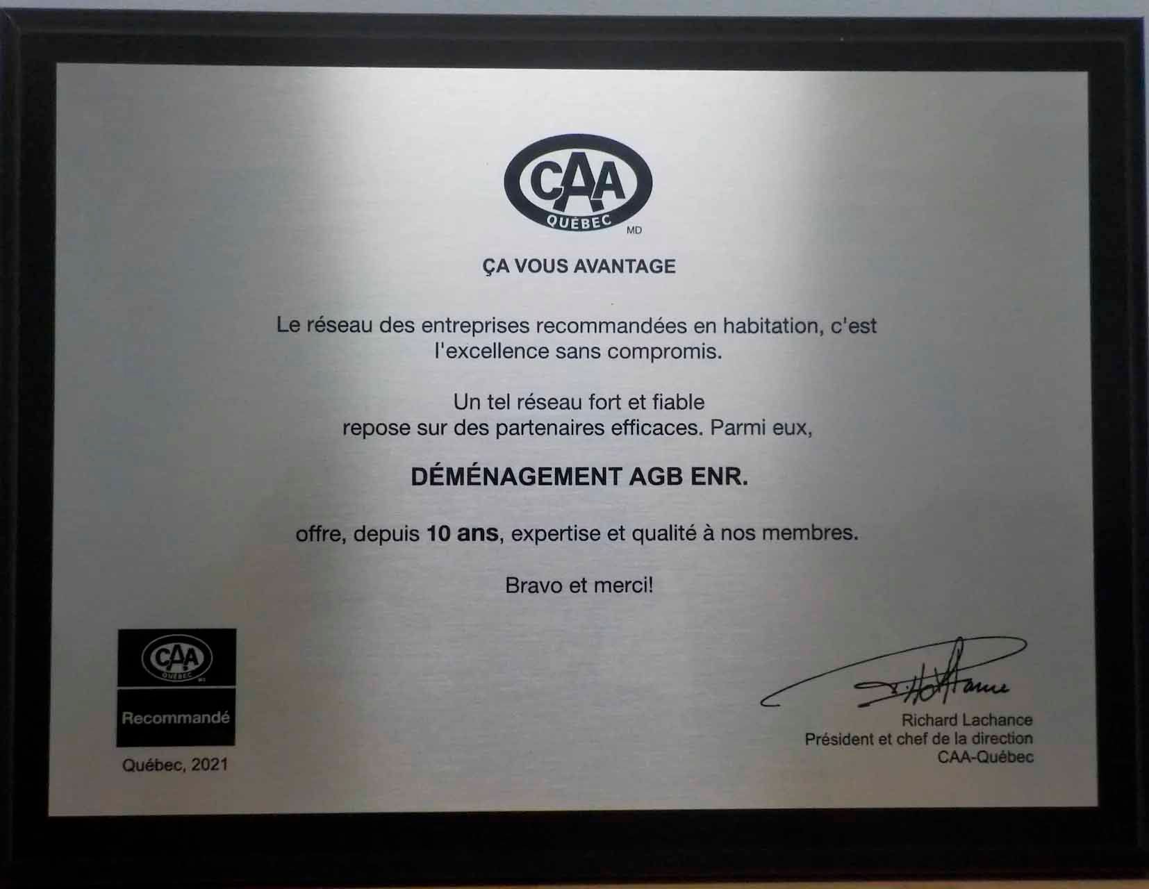 Plaque avec le logo de la CAA, un texte en français et une signature. Il semble s'agir d'une récompense.