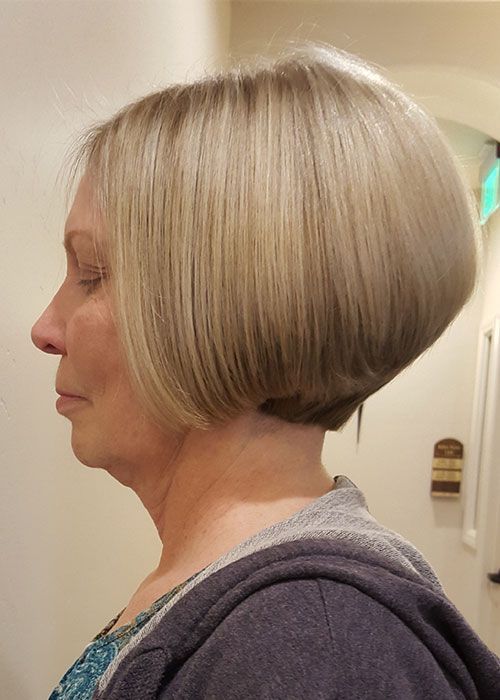 A woman with short blonde hair is wearing a hoodie.