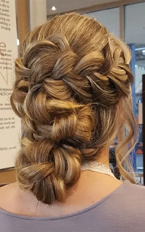 A woman is wearing her hair in a braided bun.