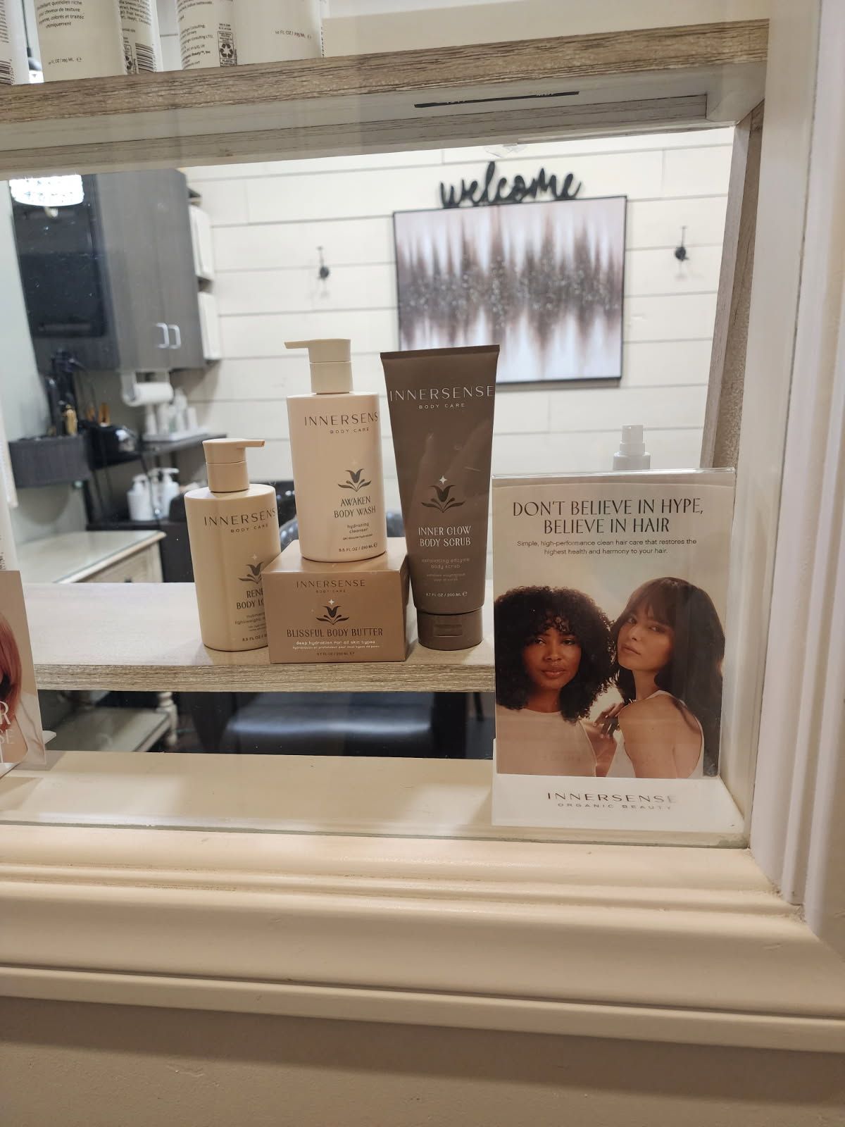 A window in a salon with a display of hair products.