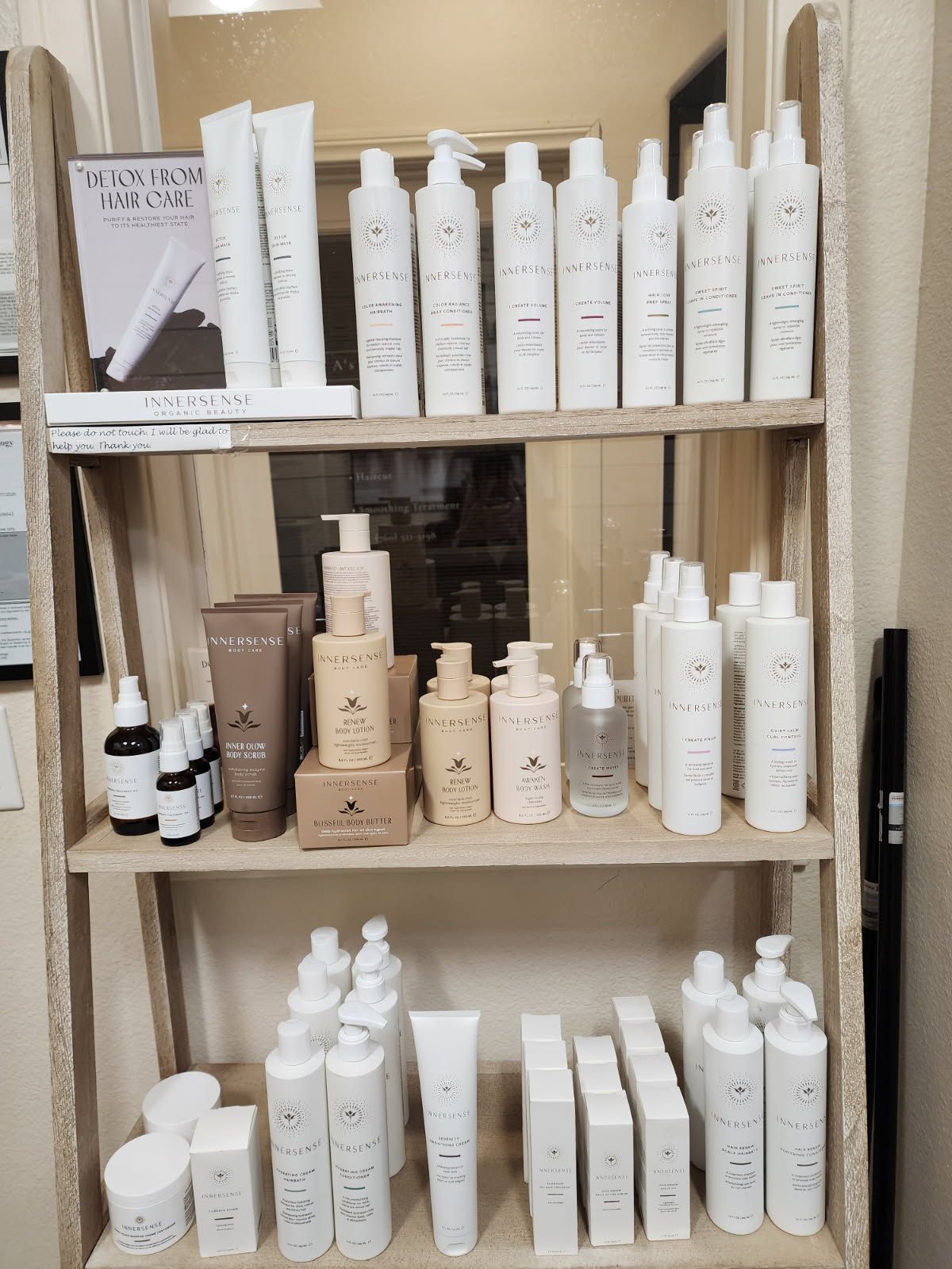 A shelf filled with lots of white bottles of cosmetics.