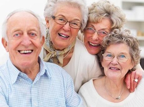 a group of elderly people are posing for a picture and smiling .
