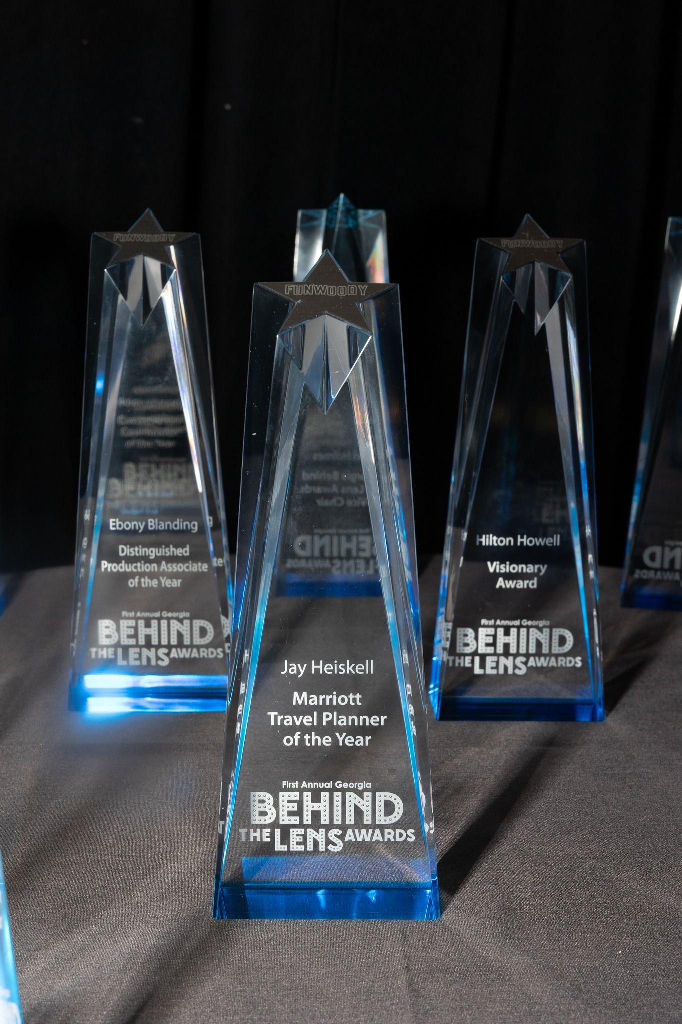 A group of behind the lens trophies are sitting on a table.