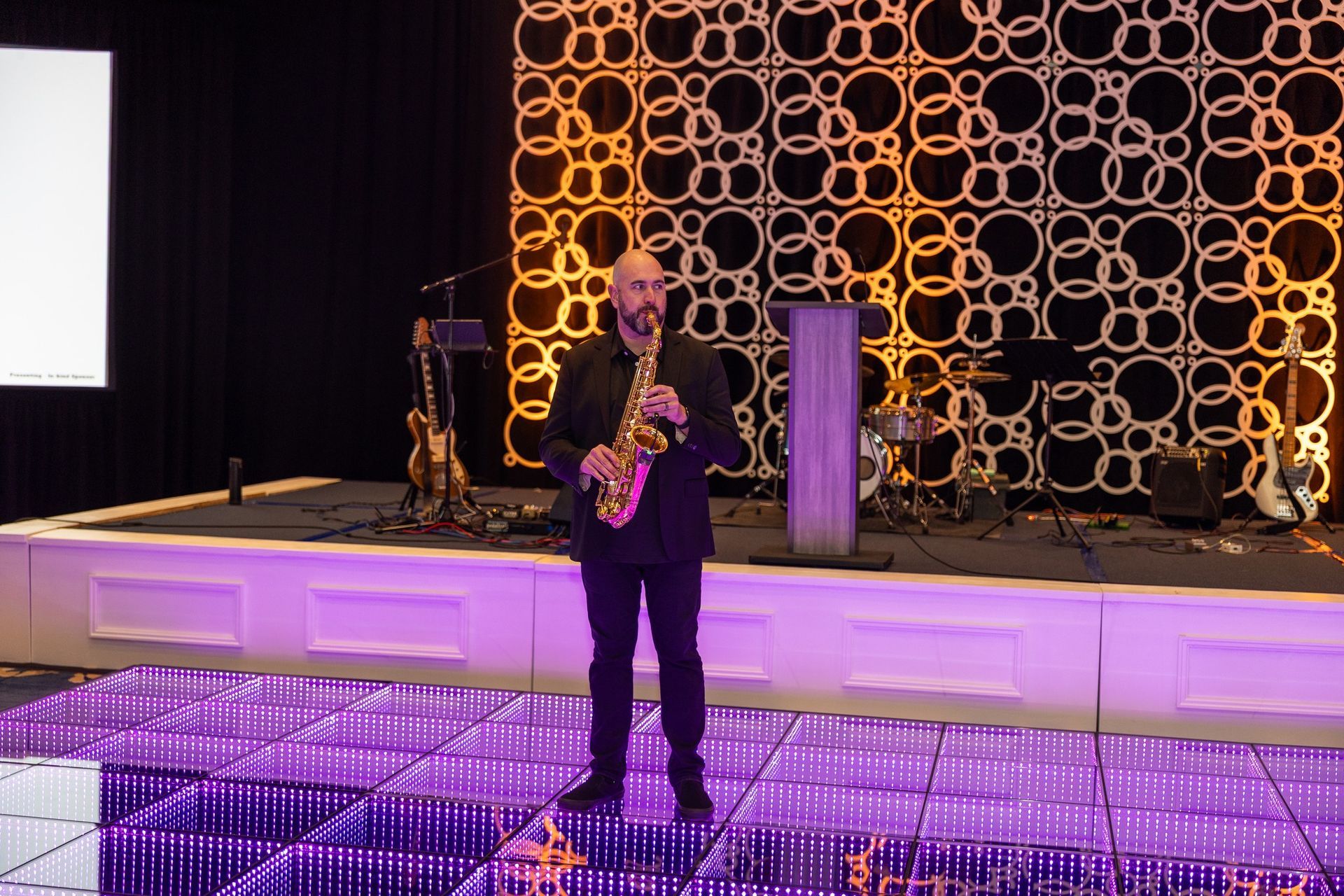 A man is playing a saxophone on a stage.