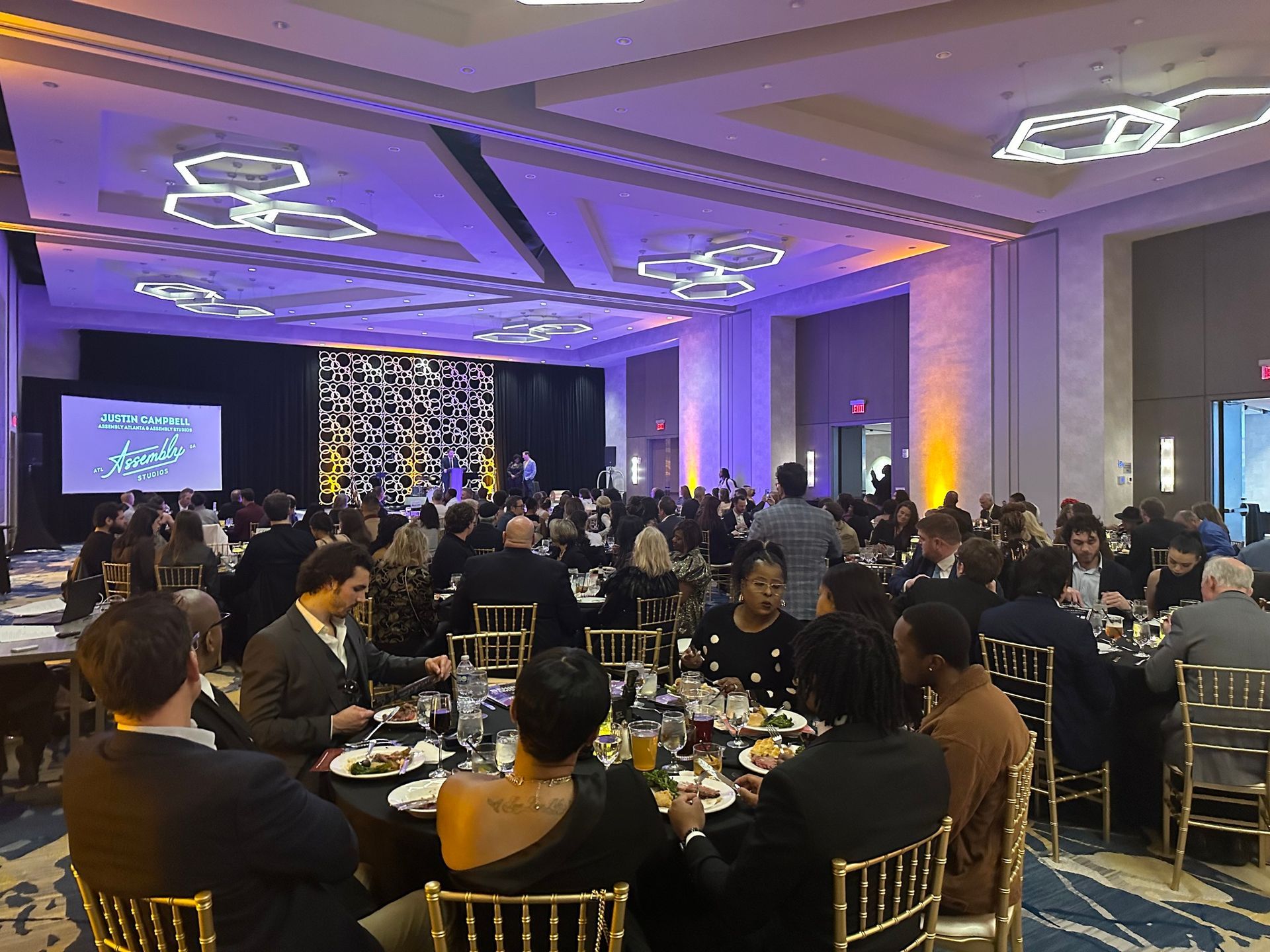 A large group of people are sitting at tables in a large room.