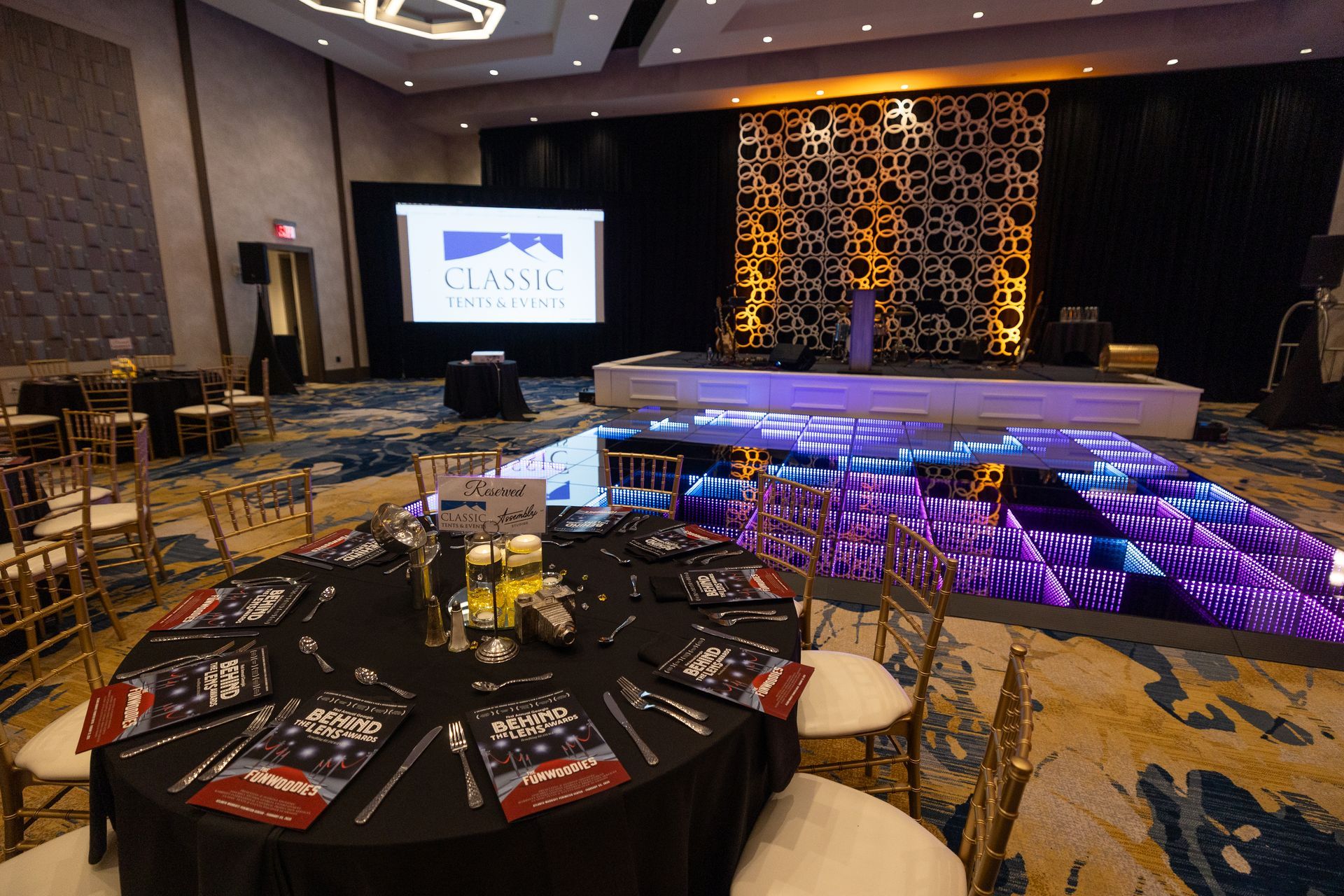 A large room with tables and chairs and a dance floor.