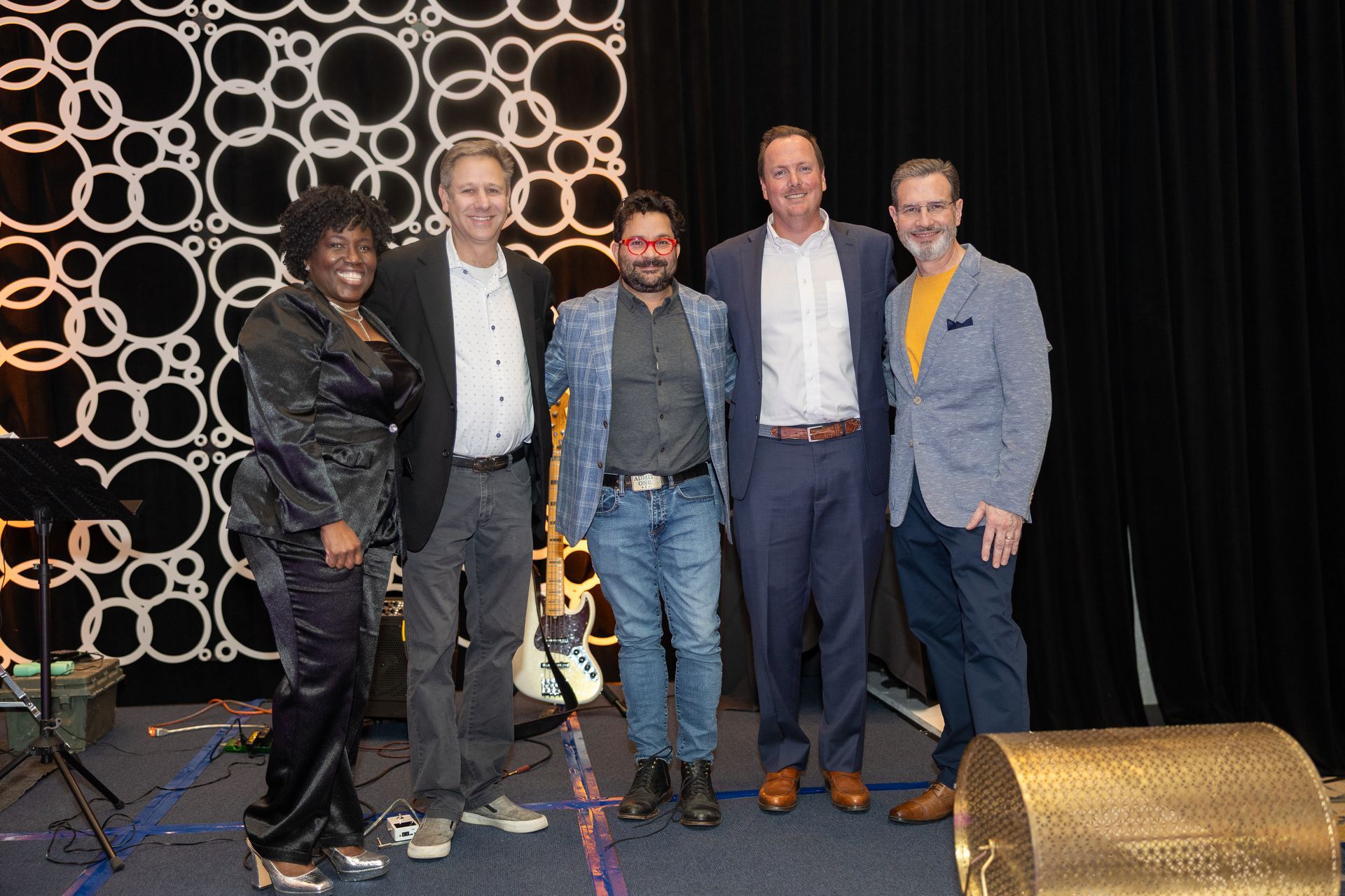 A group of people are posing for a picture on a stage.