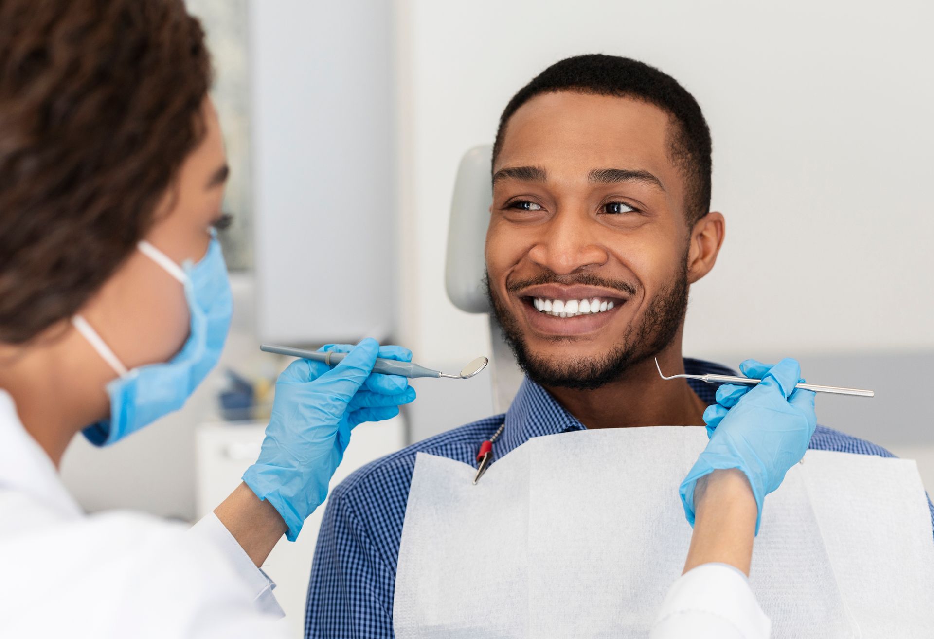 A woman is getting her teeth examined by a dentist.