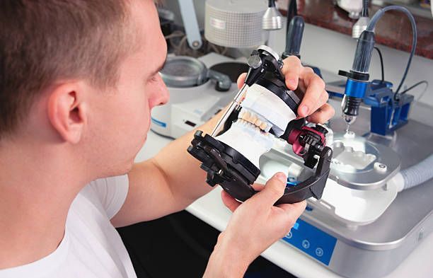 A close-up of a dental technician manufacturing dental ceramic crowns.