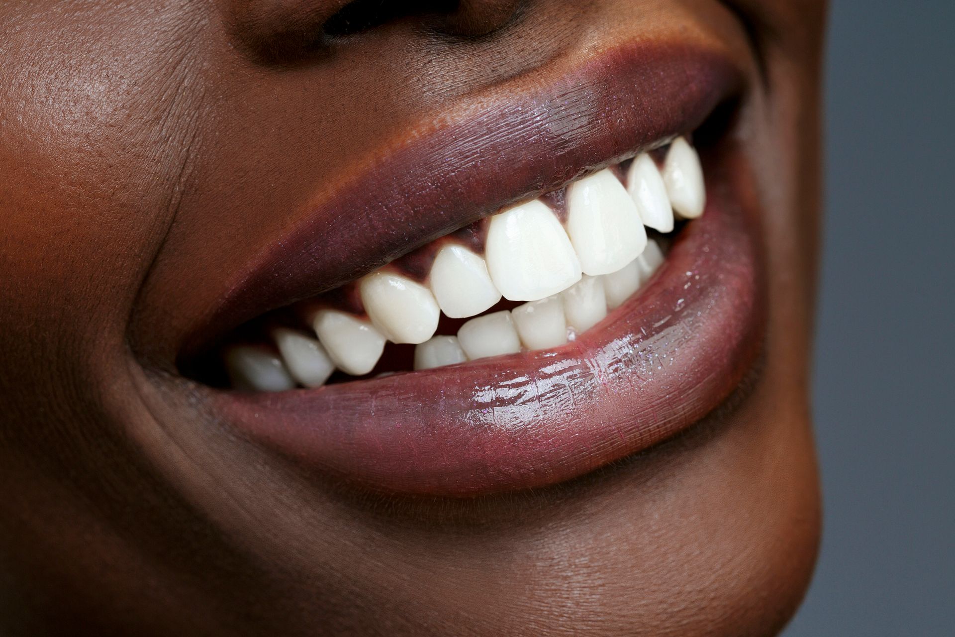 A close up of a person's mouth with yellow teeth and white teeth.