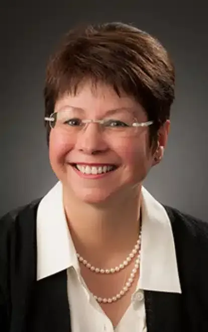 A dentist is examining a woman's teeth in a dental office.