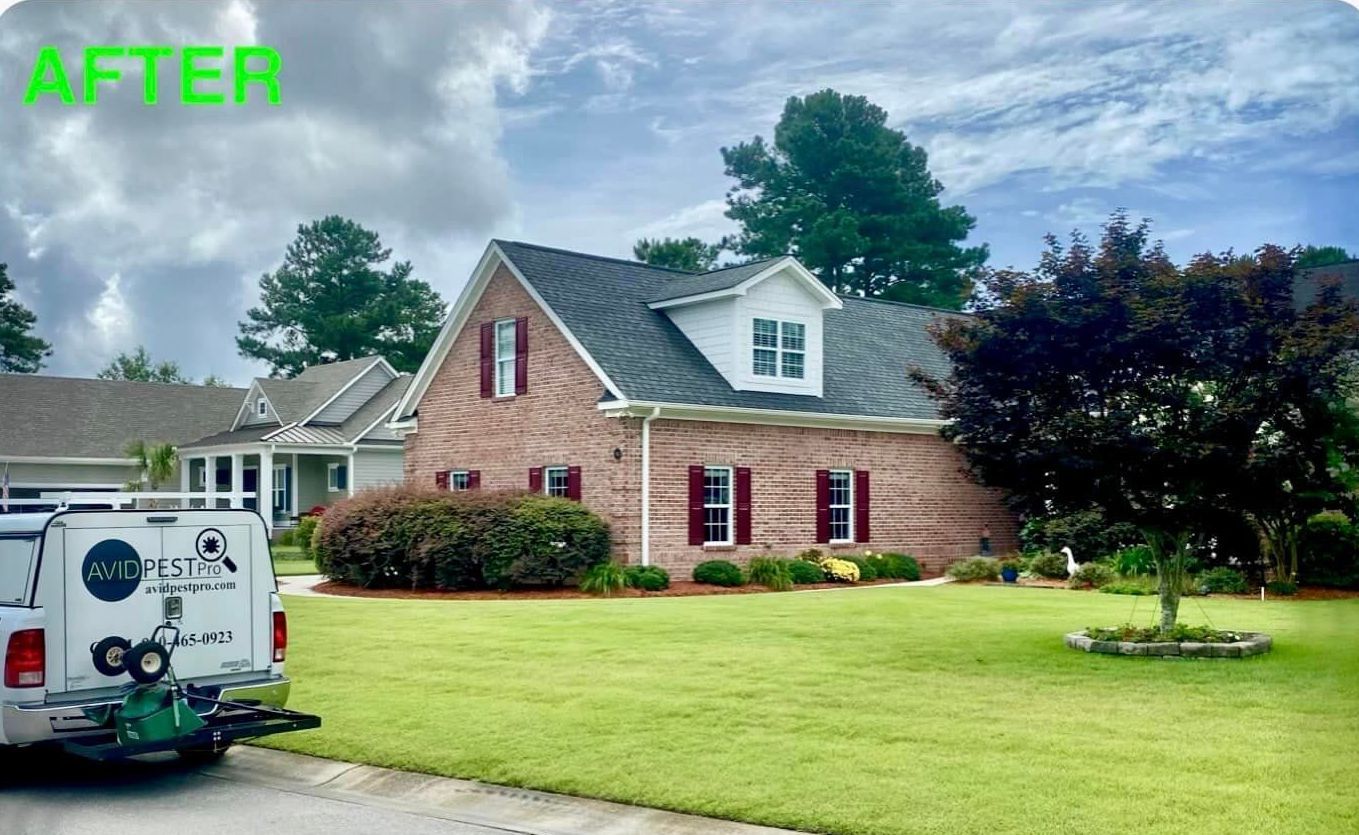 A white truck is parked in front of a large white house.
