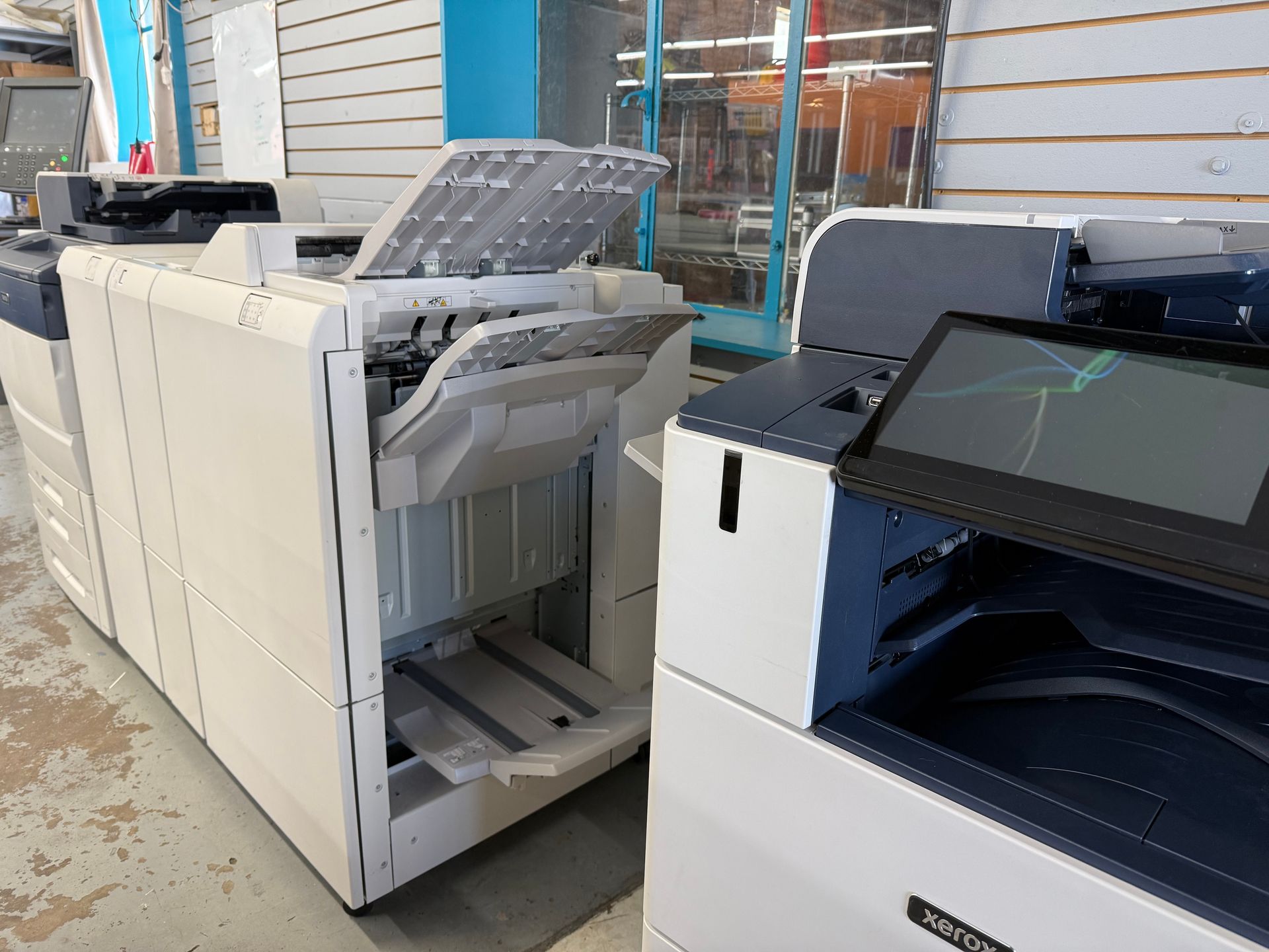Two copiers are sitting next to each other in a store.