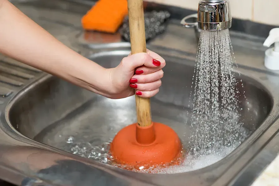 An emergency plumber unblocking a sink.