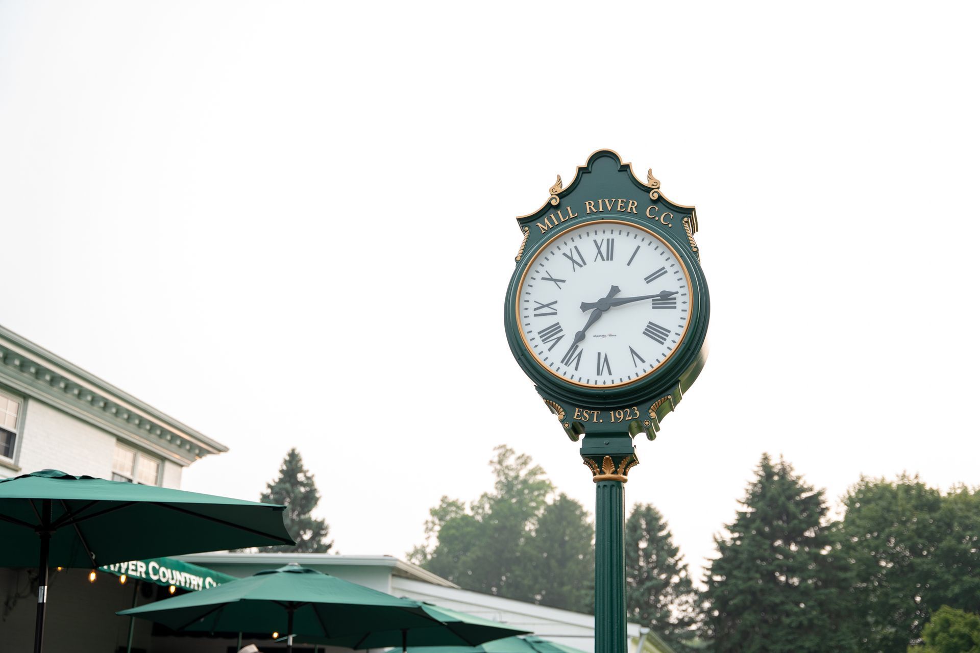 A green clock with roman numerals on it