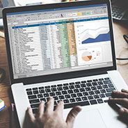 a person is typing on a laptop computer with a graph on the screen .