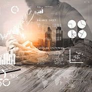 a man is sitting at a desk using a laptop computer .