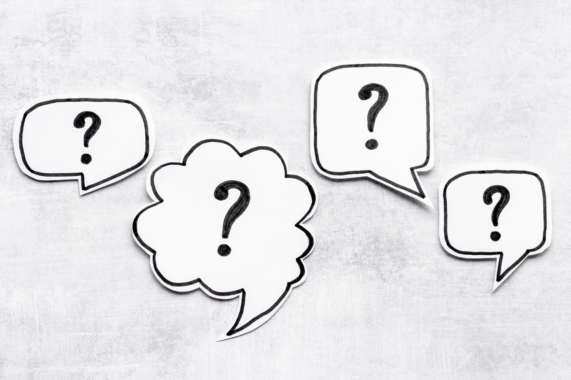 four speech bubbles with question marks on them
