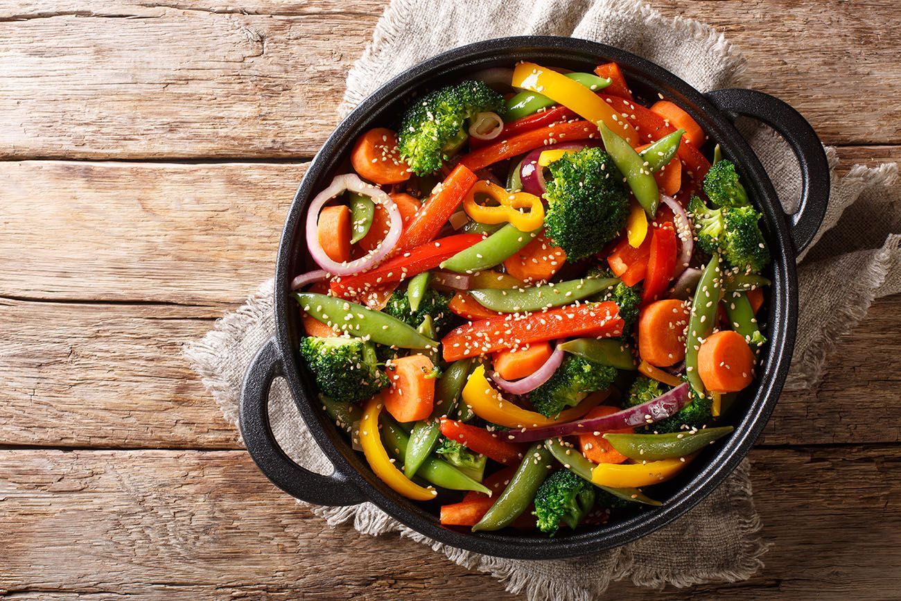 a pan filled with vegetables on a wooden table