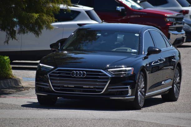 A black audi a8 is parked in a parking lot.