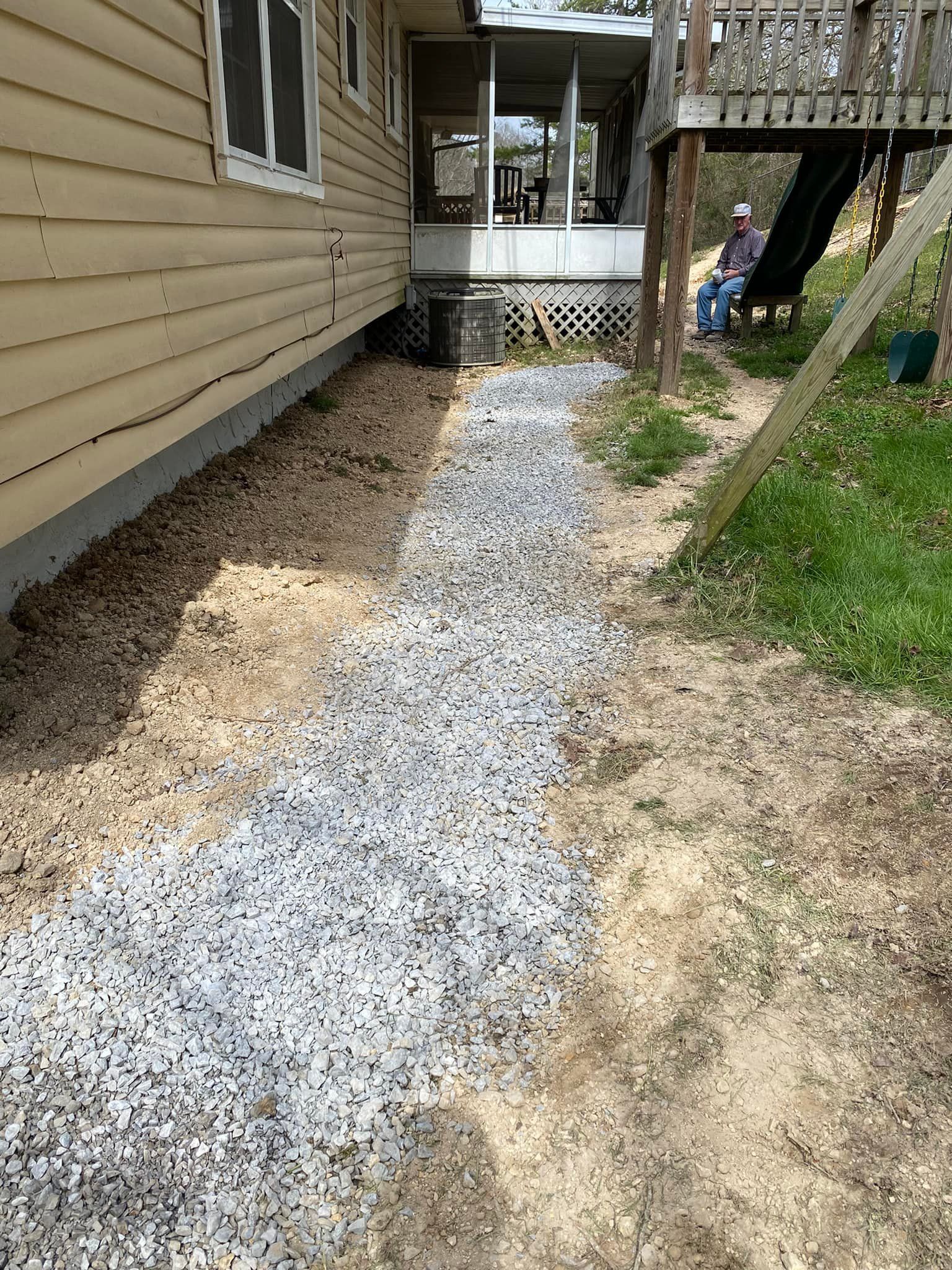 a gravel path leading to a house with a slide in the background .